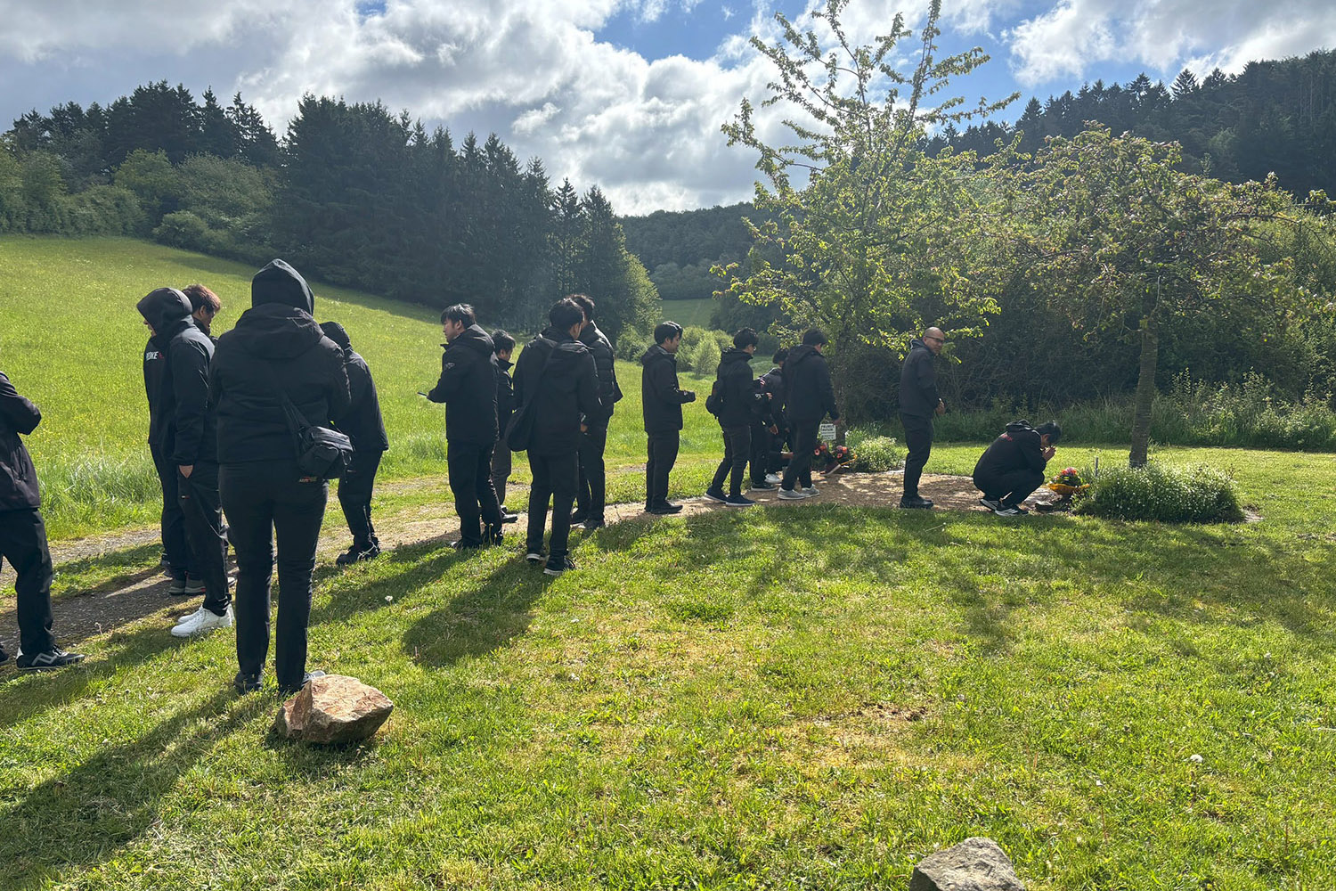 The team pays its respects at the Hiromu Naruse memorial garden