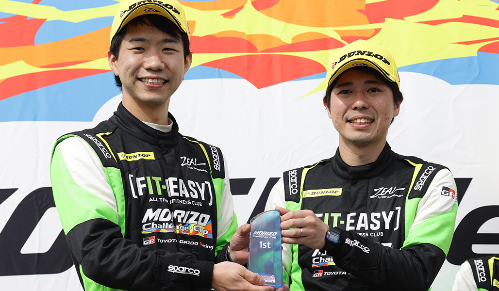 MCC独自の表彰式でトロフィーを掲げる山田選手（左）と藤井選手
