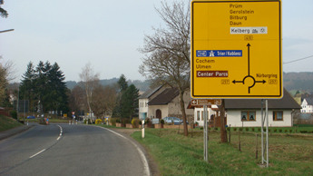 ドイツです。ニュルブルクリンク近郊です。ランナバウトの直前にはかならず、こんな標識が立ってます。クルっと回って、どっちから弾ければいいかが一目でわかります。右が「ニュルブルクリンク」ですね。