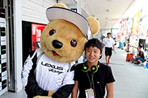 レクサス くま吉 パドック裏でGOODSMILE RACING & TeamUKYOのチームシャツを着た男性と