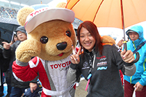 トヨタ くま吉 P.MU/CERUMO·INGINGのチーム関係者の方と傘をさしながら