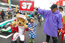 トヨタ くま吉 中嶋選手のナンバーボードを持つ雲模様のかっぱを着た親子と