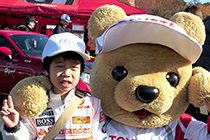 トヨタ くま吉とマクラーレンレーシングスーツ姿のファンの男の子
