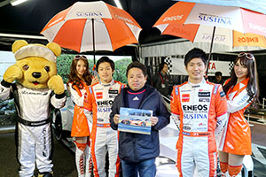 レクサス くま吉 LEXUS TEAM LeMans ENEOSのドライバーとコンパニオンとサイン入りのマシンの写真を持った男性と@ TGRP 横浜