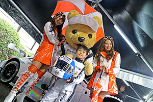 レクサス くま吉 LEXUS TEAM LeMans ENEOSのコンパニオンとレクサススーツのヘルメットを両手で抱えた少年と@ TGRP 横浜