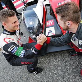 A TOYOTA GAZOO Racing mechanic shake hands with an Audi Sport Team Joest mechanic