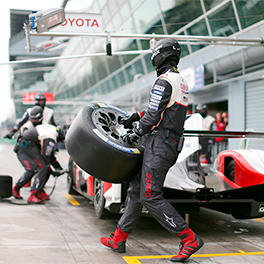 A TOYOTA GAZOO Racing mechanic carrying a tyre