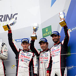 The drivers of the 3rd on the podium: Mike Conway, Kamui Kobayashi and José María López