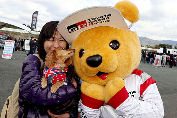 トヨタ くま吉 星柄のドッグウェアを着たダックスフンドを抱く飼い主の女性と一緒に@ モースポフェス in 九州