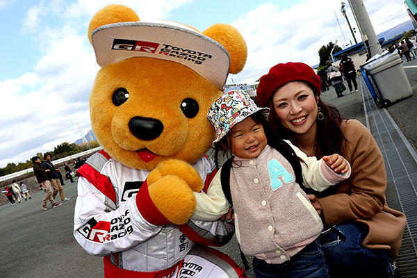 トヨタ くま吉 赤のベレー帽をかぶった女性と黒いリュックを背負った女の子と一緒に@ モースポフェス in 九州