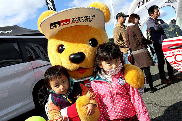 トヨタ くま吉 ハート柄のピンクの上着を着た女の子と黄緑の風船を握ってる男の子と一緒に@ モースポフェス in 九州