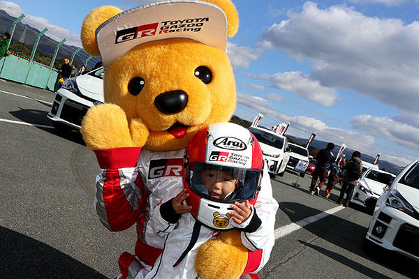 トヨタ くま吉 なりきり撮影会のレーシングスーツにヘルメットをかぶった男の子と一緒に@ モースポフェス in 九州