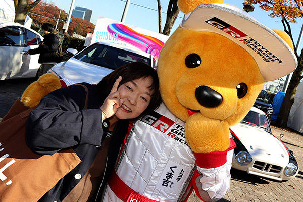 トヨタ くま吉 茶色のトートバッグを肩がけした女性と一緒に@ SHIBUYA SPORTS CAR FES 2017