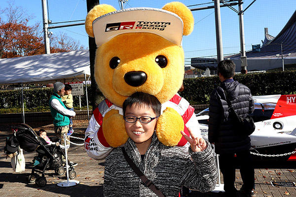 トヨタ くま吉 ショルダーバッグをたすきがけした男の子の後ろに回って2ショット@ SHIBUYA SPORTS CAR FES 2017